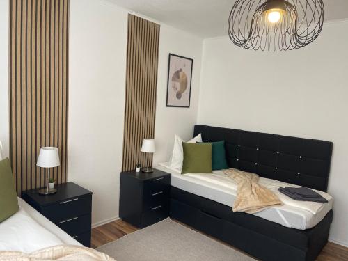 una camera con letto e testiera nera di Charmantes Familienrefugium im Zentrum von Ludwigshafen - Eleganz & Komfort Ideal fur Familien a Ludwigshafen am Rhein