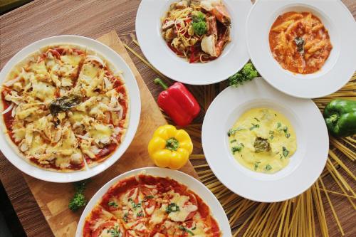 a table with four plates of food on it at Grand Diamond Hotel Yogyakarta - Formerly Grand Quallity Hotel in Yogyakarta