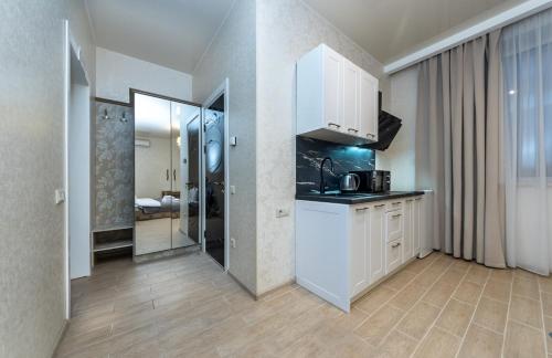 a kitchen with white cabinets and a sink at Viktoriya Family 2 Country complex in Kyiv