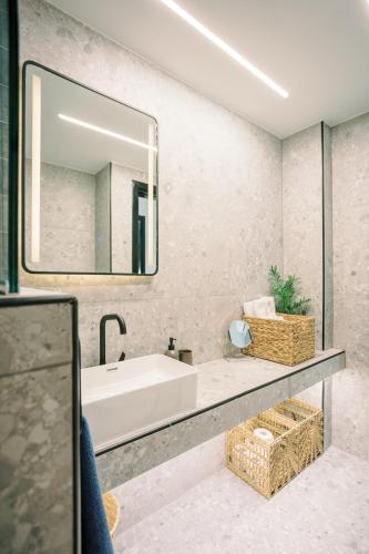a bathroom with a tub and a large mirror at 2BR Amalfi Blue Apt in Larnaca - Pool & 10Min Walk to Mackenzie Beach! in Larnaca