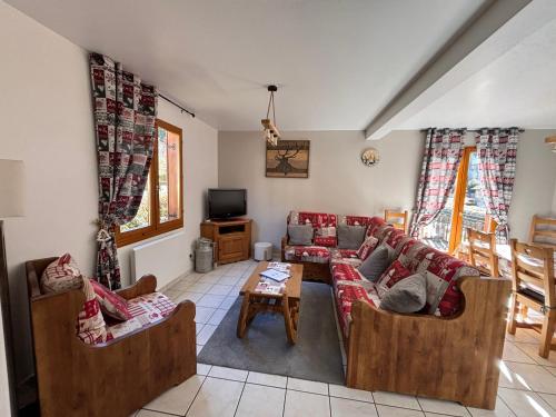 un salon avec des canapés et une télévision dans l'établissement Chalet Au fil de l'eau, à Gérardmer