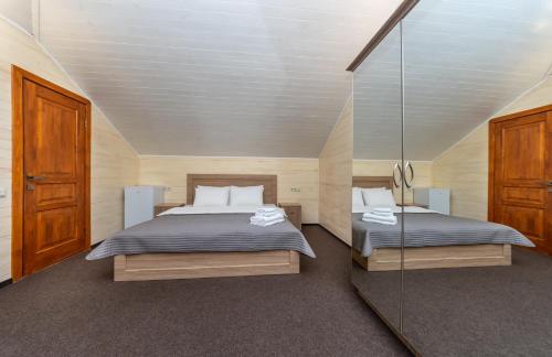 a bedroom with two beds and a glass wall at Viktoriya Family 2 Country complex in Kyiv