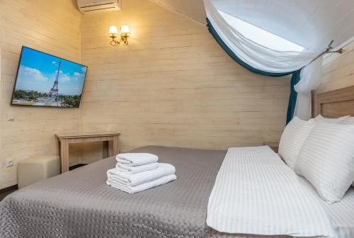 a bedroom with a bed with towels on it at Viktoriya Family 2 Country complex in Kyiv