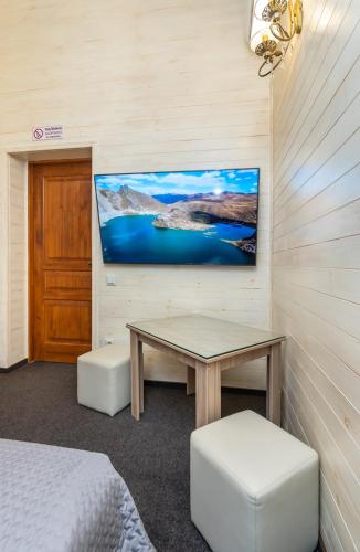 a room with a table and a tv on the wall at Viktoriya Family 2 Country complex in Kyiv