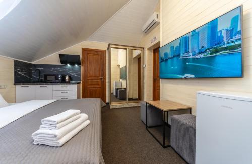 a bedroom with a bed and a tv on a wall at Viktoriya Family 2 Country complex in Kyiv