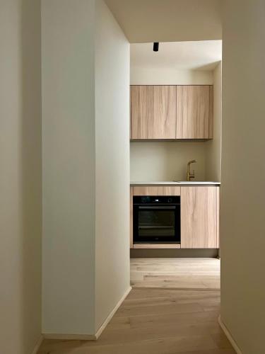 - une cuisine avec des murs blancs et des placards en bois dans l'établissement MAGNOLIA Appartement déco, à La Ciotat