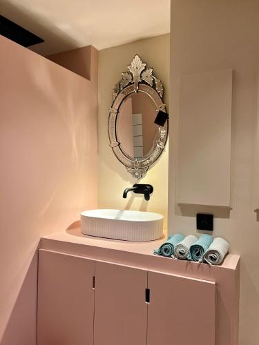 une salle de bain avec un lavabo et un miroir dans l'établissement MAGNOLIA Appartement déco, à La Ciotat
