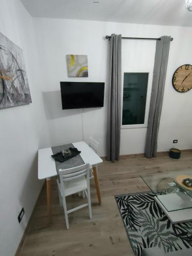 a living room with a table and a tv on the wall at Casa di Teo in Piombino
