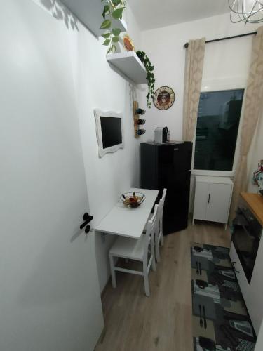 a small kitchen with a white table and a television at Casa di Teo in Piombino