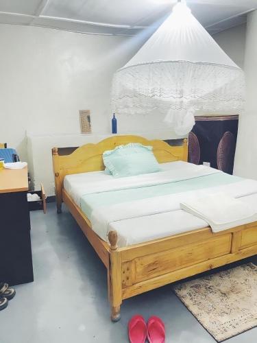 a bedroom with a wooden bed in a room at Belle Africa Kigali in Kigali