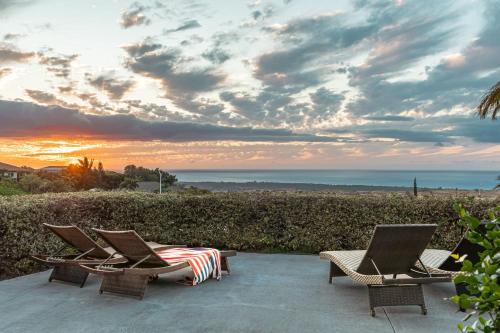 a group of chairs sitting on a patio with a sunset at 1 Acre PRIVATE RESORT 4 bed 3 bath cinema spa in Waikoloa Village