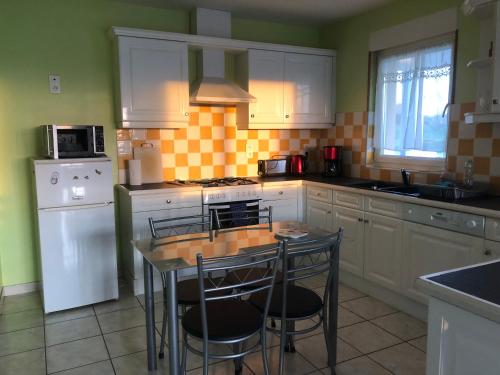 a kitchen with a table and chairs in it at Gîte Argouges in Argouges