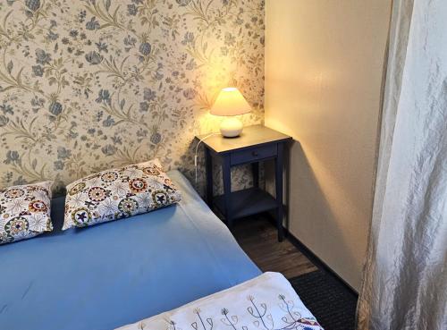 a bedroom with a bed and a lamp on a table at Lossikambri külaliskorterid in Viljandi