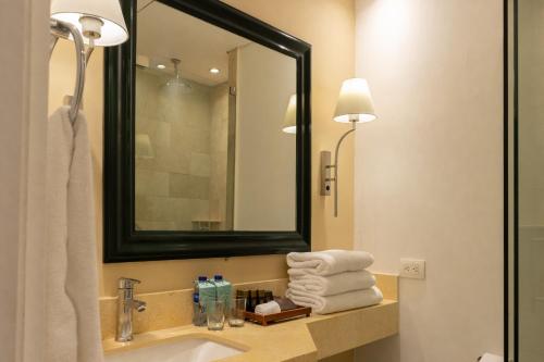 a bathroom with a sink and a mirror and towels at Hotel Caribe by Faranda Grand, a member of Radisson Individuals in Cartagena de Indias