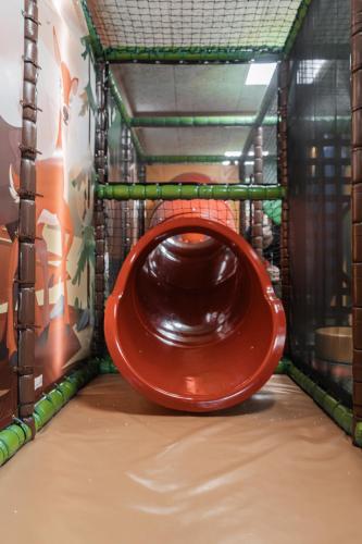 a playground with a red slide in a cage at Berghotel Arthurhaus in Mühlbach am Hochkönig