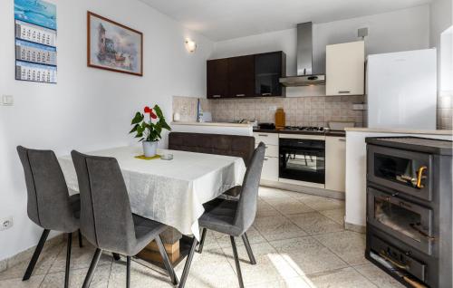 a kitchen with a table and chairs and a stove at Awesome Apartment In Novi Vinodolski in Novi Vinodolski