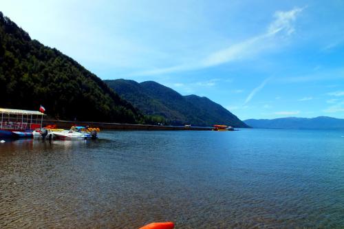 a large body of water with mountains in the background at Cabañas Los Canelos Pucon, Hermosa Granja de 20 hectaréas a orillas del Río Liucura in Pucón