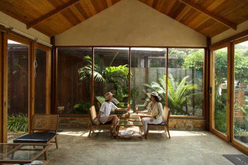 two people sitting at a table on a patio at Mamori House at Kohlarn in Ko Larn