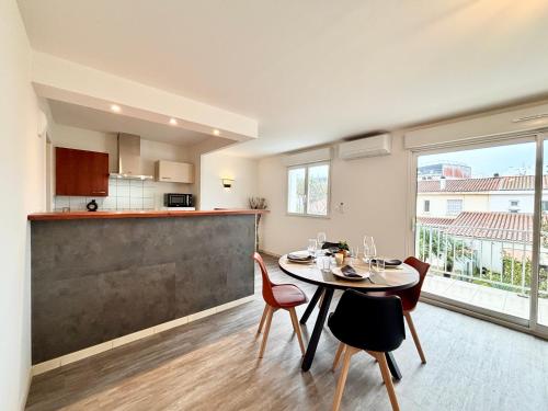 une cuisine et une salle à manger avec une table et des chaises dans l'établissement Le Rayonnant, Lumineux, Centre-ville, à Royan