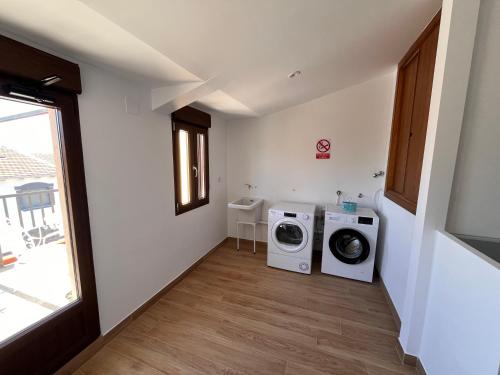 a laundry room with two washing machines and a window at Mar de Nubes Piornal 3 in Piornal