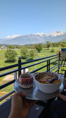 a table with a bowl of food and a cup of coffee at Nivaara in Bīr