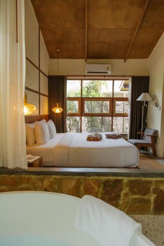 a bedroom with a large bed and a large window at Mamori House at Kohlarn in Ko Larn