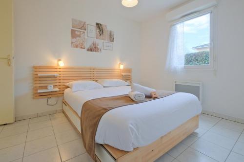 - une chambre dotée d'un grand lit avec des draps blancs et une fenêtre dans l'établissement Lit d'Isle, à Marsac-sur-lʼIsle