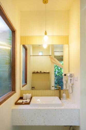 a bathroom with a large white tub and a mirror at Mamori House at Kohlarn in Ko Larn