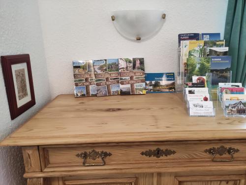 a wooden dresser with magazines on top of it at Ferienwohnung Ziegler in Simmerath