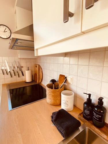 a kitchen counter with a sink and a clock at KIPOS-SS residences in Dassia