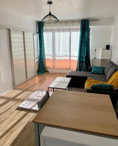 un salon avec un canapé et une table dans l'établissement Appartement 40 m2 avec parking gratuit, à Nanterre