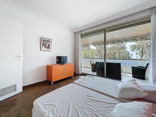 une chambre avec deux lits et une grande fenêtre dans l'établissement 61m2 - terrasse vue mer, croisette, à Cannes