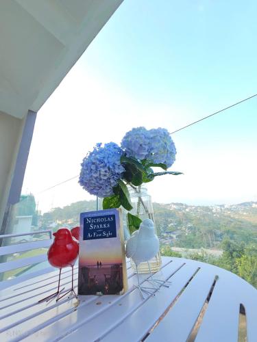 a book and a vase of flowers on a table at The Luxe Da Lat in Da Lat