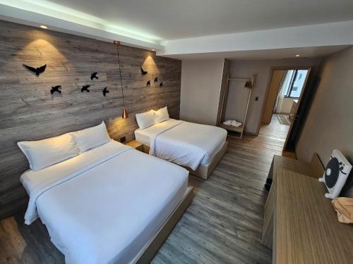 a hotel room with two beds and birds on the wall at The Luxe Da Lat in Da Lat