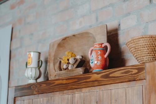 a shelf with a vase and other items on it at História Présház boutique Nagyréde in Gyöngyös