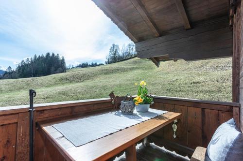 a table on a porch with a view of a field at Bio-Bauernhof Niederlehen in Fieberbrunn