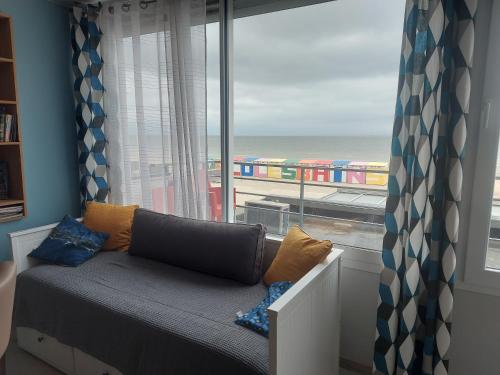 - un siège de fenêtre dans une chambre avec vue sur un train dans l'établissement Appartement de standing bord de plage malo, à Dunkerque