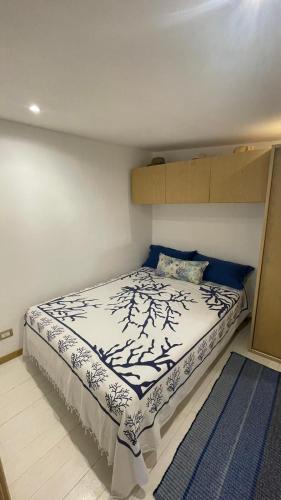 a bedroom with a bed with a white and blue comforter at Dreaming Cefalù in Cefalù
