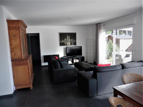 un salon avec deux canapés et une télévision dans l'établissement bee free, à Montalivet-les-Bains