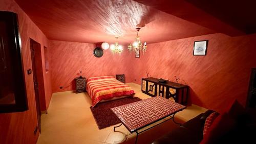 a room with a bed and a table and a chandelier at Villa DARANA in Douaïra