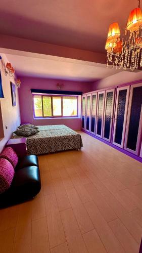 a bedroom with two beds and a chandelier at Villa DARANA in Douaïra