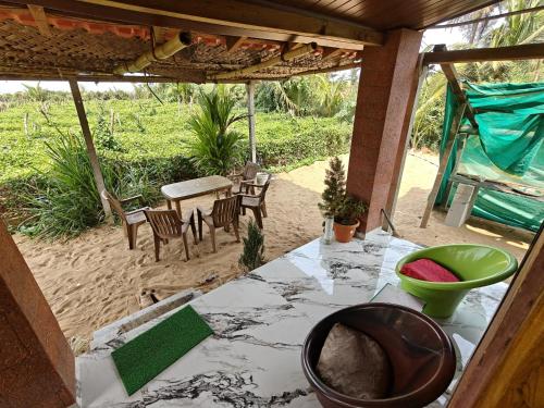 an outside view of a house with a table and chairs at Nakshatra Beach Stay in Gokarn