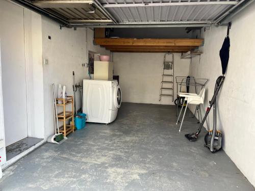 a garage with a refrigerator and a ladder in it at Maison familiale et chaleureuse à la chaume av 2 chambres, terrasse, wifi in Les Sables-dʼOlonne