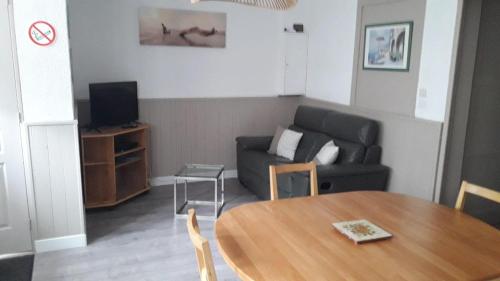 un salon avec une table et un canapé dans l'établissement Appartement , 500 m de la mer, à Le Portel