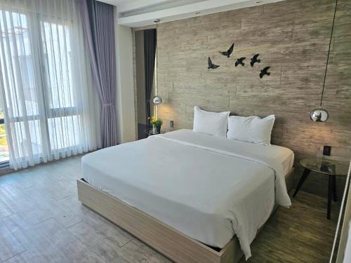 a bedroom with a large bed with birds on the wall at The Luxe Da Lat in Da Lat