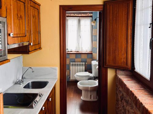 a small kitchen with a toilet and a sink and a sink at Apartamentos Villa Fresnedo in Solares
