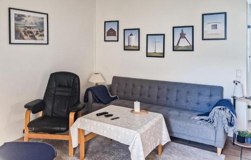 a living room with a blue couch and two chairs and a table at 1 Bedroom Amazing Apartment In Løkken in Løkken