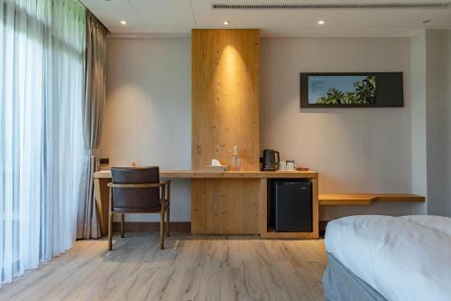 a hotel room with a desk and a bed at La Tree 普椿農場木子莊園 in Donghe