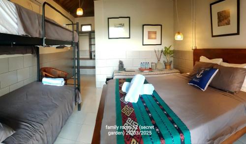 a bedroom with two bunk beds in a room at Ekas secret garden surf villas, walk to waves in Pulau Gilkaliantan