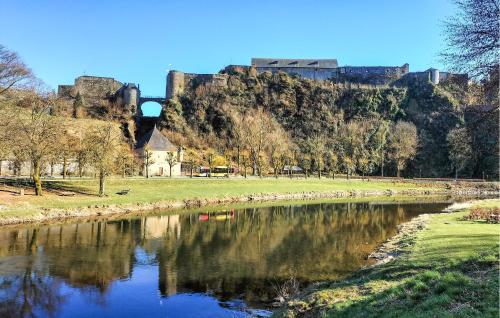 a castle sitting on top of a hill next to a river at Beautiful Apartment In Bouillon in Bouillon